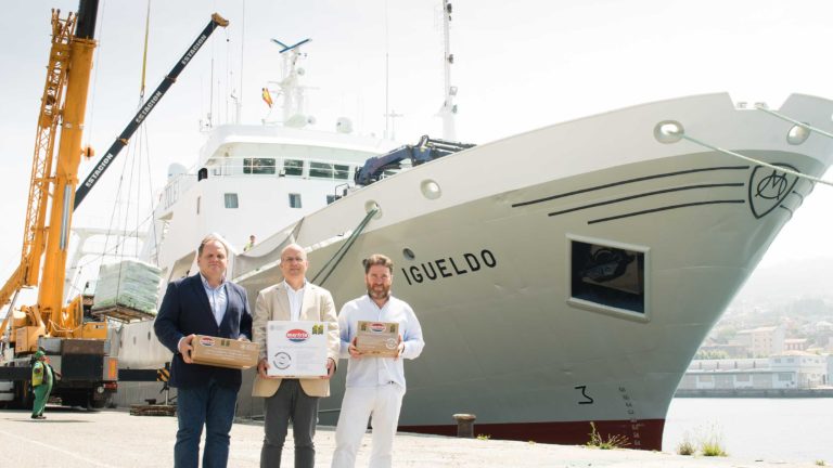 Santiago Montejo, Ramón Abeijón y Javier Otaegui frente al buque igueldo, sujetando cajas calamar patagónico